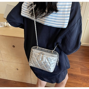 Detail of silver quilted chain bag with rhinestone studs and double zipper closure