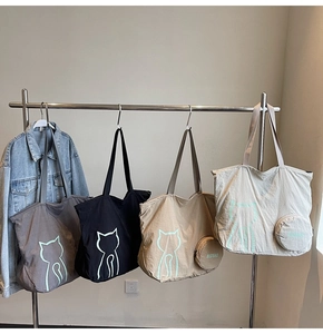 Detail of four colorful nylon tote bags with mint green cat prints and small wallets