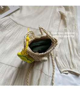 Interno spazioso della borsa a tracolla in paglia intrecciata con due smartphone
