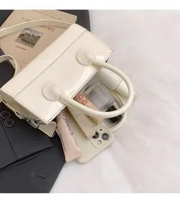Internal view of cream patent leather handbag showing space for phone and makeup