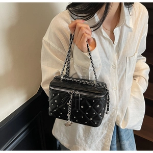 Detail of black quilted vanity case with silver rhinestones and rose charm