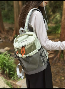 Close-up of lightweight hiking backpack with green color blocking and orange zipper pulls
