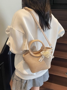 Elegant beige crocodile pattern bucket bag with pearl heart pendant and circular handle