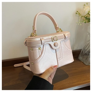 Detail of creative denim jacket style handbag in pearly pink with metallic studs