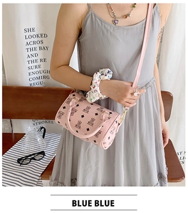 Pink cylinder crossbody bag with teddy bear pattern and golden metal hardware details