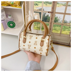 Close-up of white mini Boston bag with bear monogram print and brown leather handles