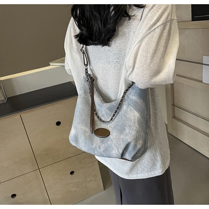 Detailansicht der Denim-Tragetasche mit Vintage-Waschung und Metallkettenriemen