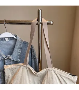 Detail of wide comfortable shoulder strap and zipper closure on cream tote bag