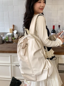 Minimalist cream beige nylon backpack with woven rope zipper detail for students