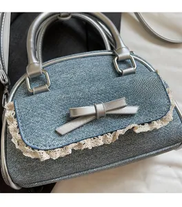 Detailed macro view of denim handbag with lace trim and silver leather bow decoration