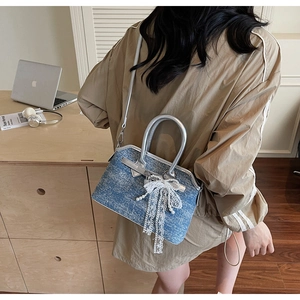 Sac à bandoulière en denim bleu avec nœud en dentelle blanche et poignée argentée