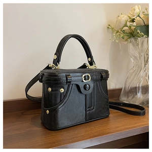 Detail of vintage black box handbag with golden hardware and unique tailoring design