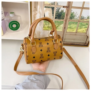 Detail of caramel boston bag featuring cartoon bear print and lychee textured leather