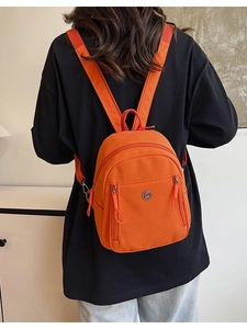 Mini sac à dos sport orange en nylon avec plusieurs poches et bandoulière large
