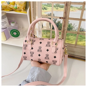 Detailed view of pink mini Boston bag with bear pattern and textured leather surface