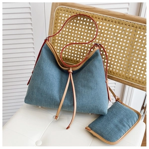 Detail of blue denim bucket bag with leather trim and matching small coin purse set