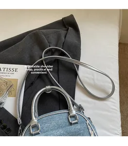 Close-up of light blue denim bow handbag with adjustable silver synthetic leather strap