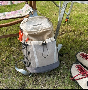 Outdoor backpack detail showing orange paracord zippers and breathable side mesh pockets