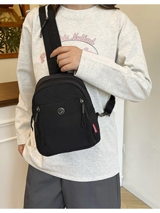Sac bandoulière minimaliste en nylon noir avec double fermeture éclair sur le modèle