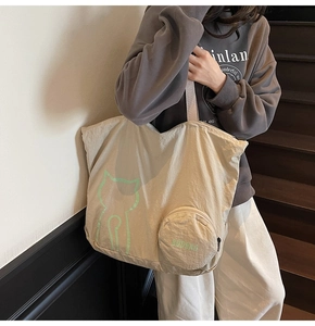 Détail du grand cabas en nylon beige avec motif de chat vert et mini pochette ronde amovible