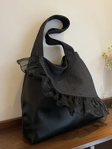 Fashionable denim tote bag with black ruffle detail and wide shoulder strap for women