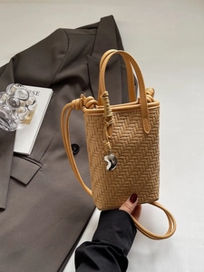 Sac seau tissé marron pour femme avec pendentif argenté et bandoulière élégante