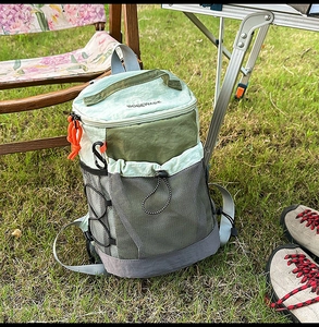 Outdoor camping scene showing a mini lightweight nylon backpack with mesh and cord detail