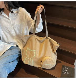 Gros plan du sac fourre-tout kaki avec imprimé chat et petit porte-monnaie sur l'escalier