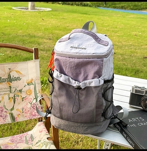Outdoor hiking backpack on a camping table featuring gray and purple color-blocking