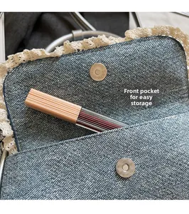 Detail of blue denim ballet-style bag featuring white lace trim and front storage pocket