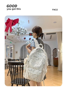 Close-up of white starry backpack with plush charm in festive Christmas setting