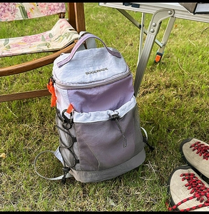 Outdoor light purple and gray hiking backpack displayed in a scenic camping setting