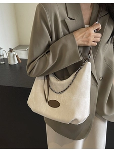 Minimalistische beige Denim-Hobo-Tasche mit braunem Lederriemen und stylischer Metallkette