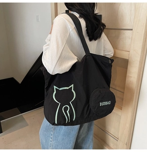 Détail du grand sac cabas noir en nylon avec motif chat vert et mini pochette ronde attachée