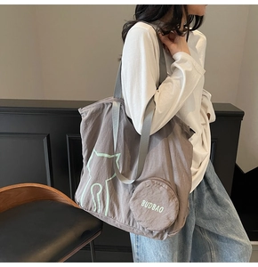 Detail of coffee brown tote bag featuring a cat pattern and a round zippered coin purse