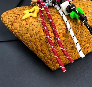 Detail of handmade woven straw bag with colorful ropes and star-shaped accents