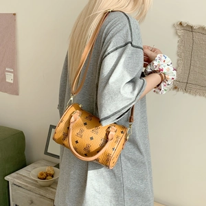 Side view of a brown cylinder shoulder bag featuring cartoon bear and diamond patterns