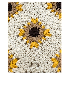 Detailed macro view of the handcrafted crochet sunflower pattern on a stylish knit bag