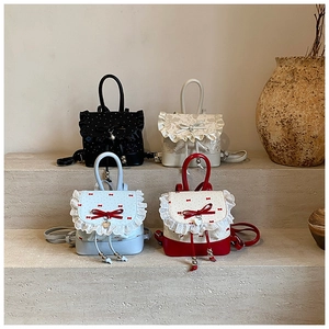 Detail of sweet ballet style mini backpacks with lace ruffles and heart pendants