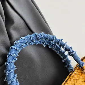 Detail of hand-woven straw bag featuring blue denim shoulder straps with frayed edges
