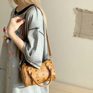 Detailed macro view of the cartoon bear print on a brown leather Boston shoulder bag