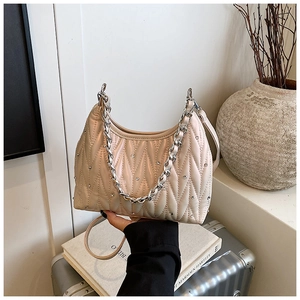 Detailansicht der champagnerfarbenen Stepptasche mit Strasssteinen und silberner Kette