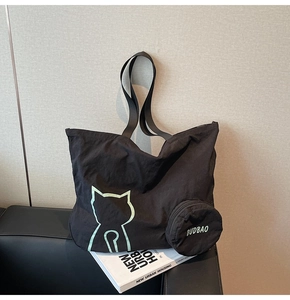 Détail du grand sac cabas noir avec motif chat vert et petit porte-monnaie assorti