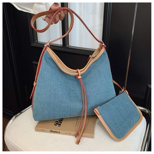 Detail view of blue denim hobo bag set with red leather trim and matching small pouch