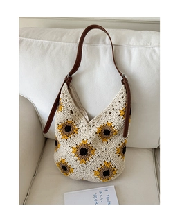 Close-up of handmade sunflower crochet tote with detailed knit texture and leather strap