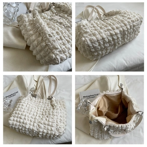 Detail view of large white popcorn texture tote bag with pearl chain and spacious interior