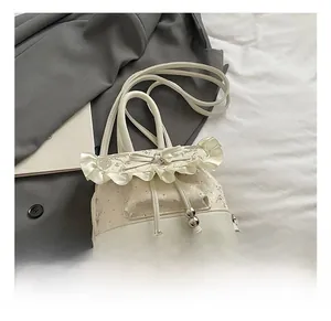 Close-up of white lace embroidery and ruffle trim with pearl bow detail on fashion backpack
