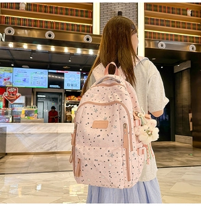 Pink star pattern backpack shown with side pockets and cute bunny plush accessory