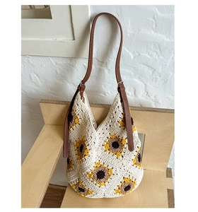 Detail of hand-woven sunflower crochet bag featuring yellow petals and brown leather strap