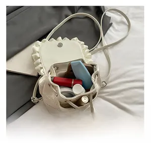 Interior view showing the large capacity for cosmetics in a white lace bucket bag